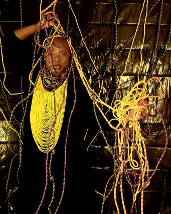 ropes draped around dani against a wall