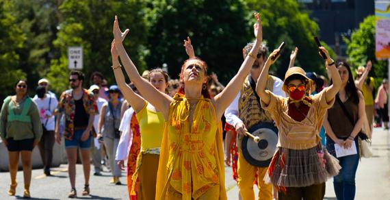Juliet McMains leading procession with raised arms 