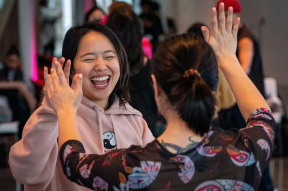 Dancers gleefully high-fiving each other.