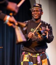Etienne Cakpo plays percussion and smiles