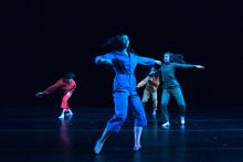 dancers dressed in bright colored jumpsuits in motion 