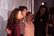 The chair of the dance department posing and laughing for a photo with three dance students at the Fall for Dance party