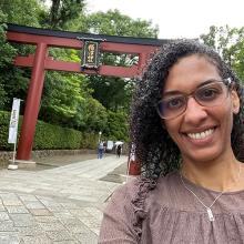 Christina Suanrdi in Tokyo, Japan  Christina Sunardi smiles in front of a Japanese "torii" gate