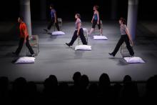5 people walking by pillows on the ground