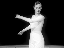 Lady in white swings arms. Photo is black and white. 