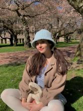 Alicia sits under cherry blossoms