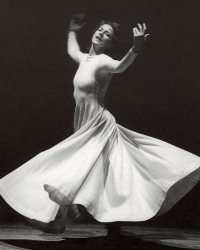 Doris Humphrey spinning in white dress with arms raised
