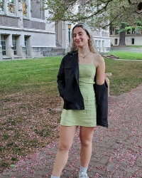 Victoria in a pale green dress under the cherry blossom trees at the UW Quad 