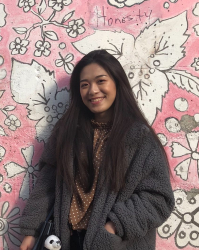 Coco in front of a pink wall 