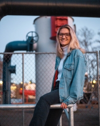 Jackie leans on a rail and smiles