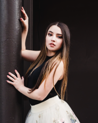 Heather leans against a pole in pointe shoes and a floral tutu 