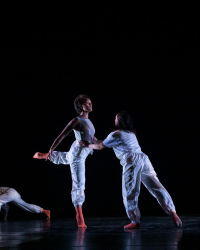Madison stands on one leg being supported by another dancer.