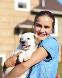 Ieva holds her dog and smiles