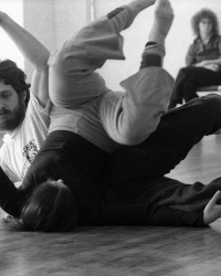 Steve Paxton rolling over another dancer on the ground with limbs in the air