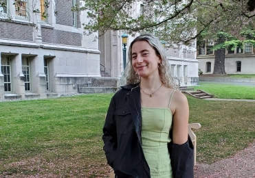 Victoria in a pale green dress under the cherry blossom trees at the UW Quad 