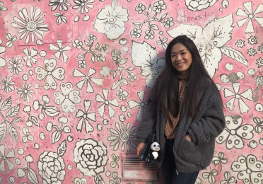 Coco in front of a pink wall 