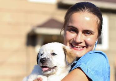 Ieva holds her dog and smiles