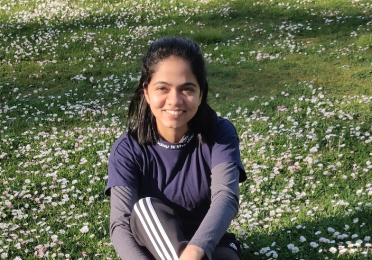 Sweekruthi sitting in a field 