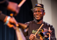 Etienne Cakpo plays percussion and smiles
