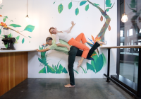 Juliet balances laying on top of Cristian who is tilted and standing on one leg 