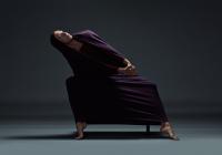 dancer in purple cloth leans over