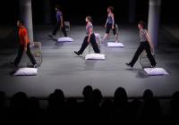5 people walking by pillows on the ground