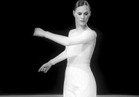 Lady in white swings arms. Photo is black and white. 