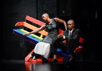 two dancers sit on a slanted bench 