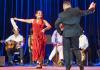 Monica Rojas Stewart dancing in a red dress with a partner and handkerchief 