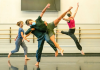 Dances leaping and tumbling over and around each other in the studio 