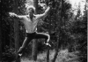 Douglas Dunn jumping high infront of tree trunks 