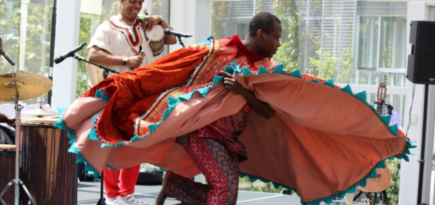 Etienne Cakpo dancing in a wide orange dress