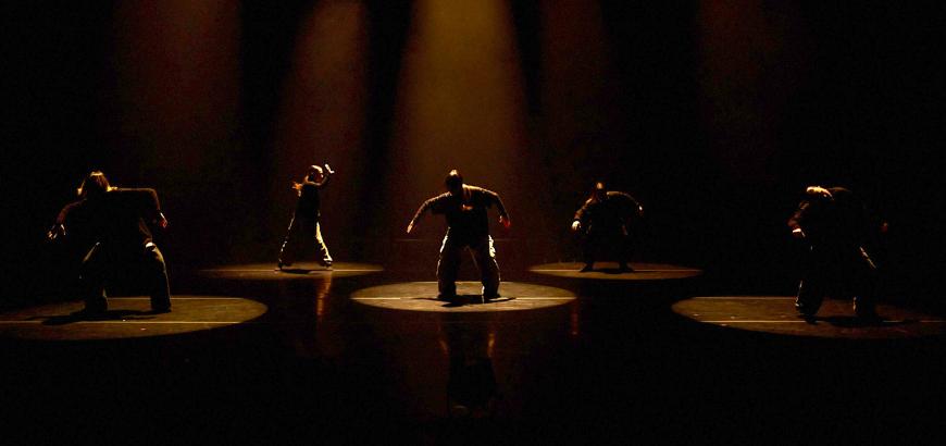 Dancers on stage in pools of light