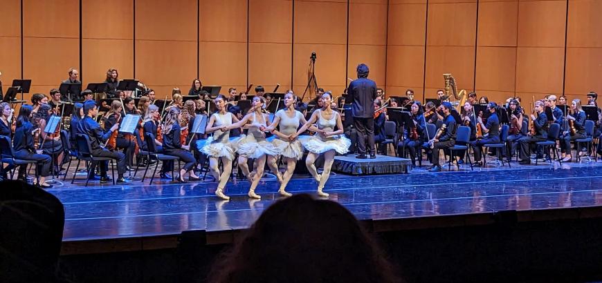 Four dancers performing &quot;dance of the little swans&quot; in front of the orchestra on Meany Hall stage