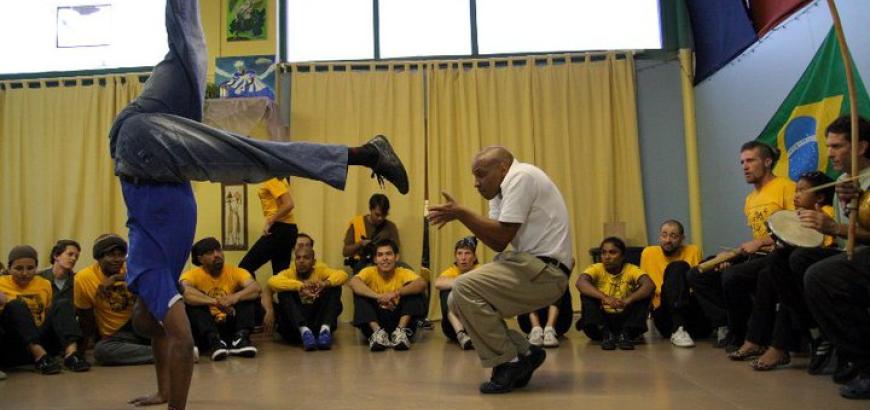Silvio crouched playing capoeira
