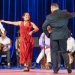 Monica Rojas Stewart dancing in a red dress with a partner and handkerchief 