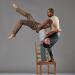 Jo stands on a chair while holding Fausto that is upside down. 