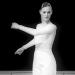 Lady in white swings arms. Photo is black and white. 